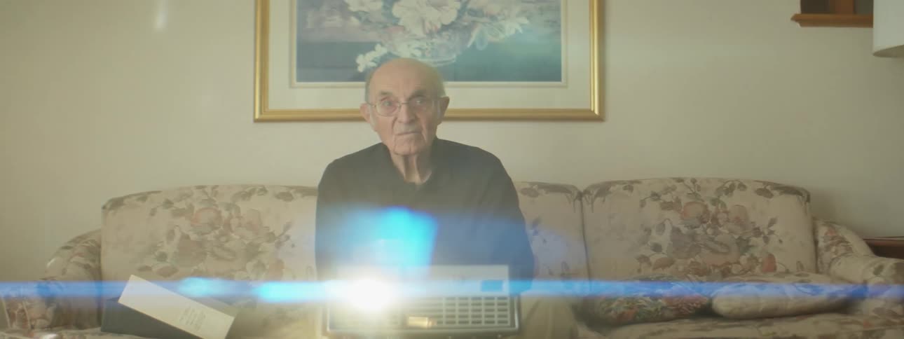 Elderly man looking at slides on a carrousel projector in the living room at home