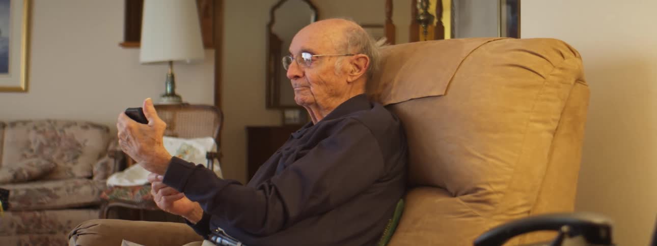 A man that is using a remote in a room