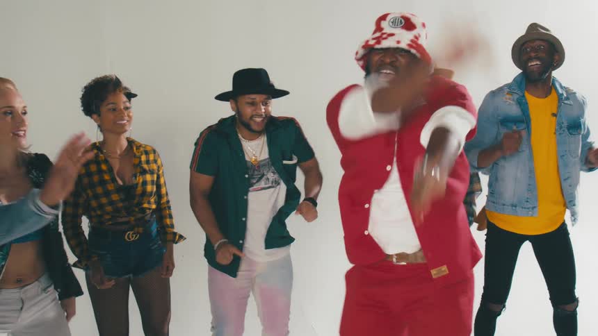 Group of young people energetically dancing in front of a white background