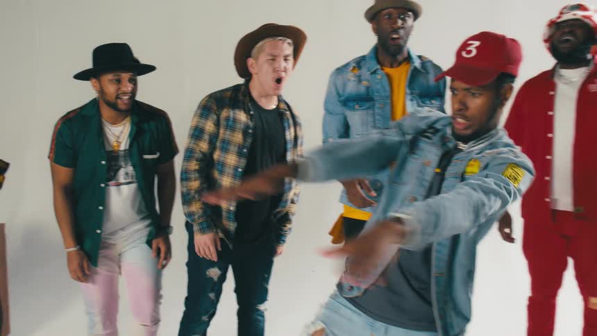 Group of young people energetically dancing in front of a white background
