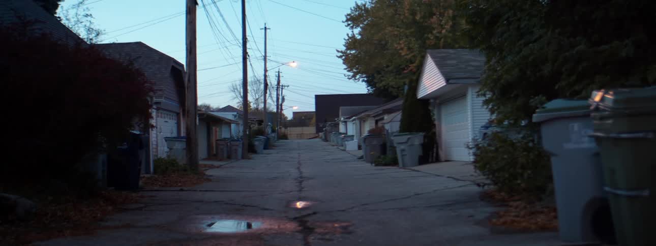 A narrow road through a dense neighborhood in the evening