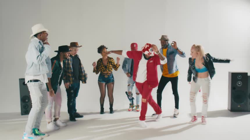 Group of young people energetically dancing in front of a white background