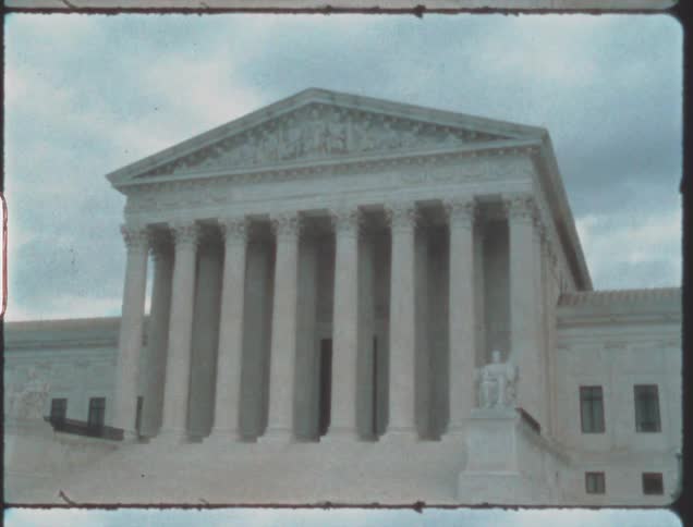 A large government building under a cloudy daytime sky