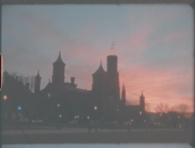 Pedestrians walk around near tourist attractions under a red sky