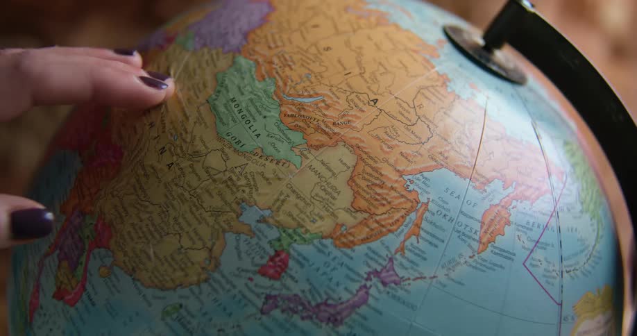 A woman in a room touching a globe