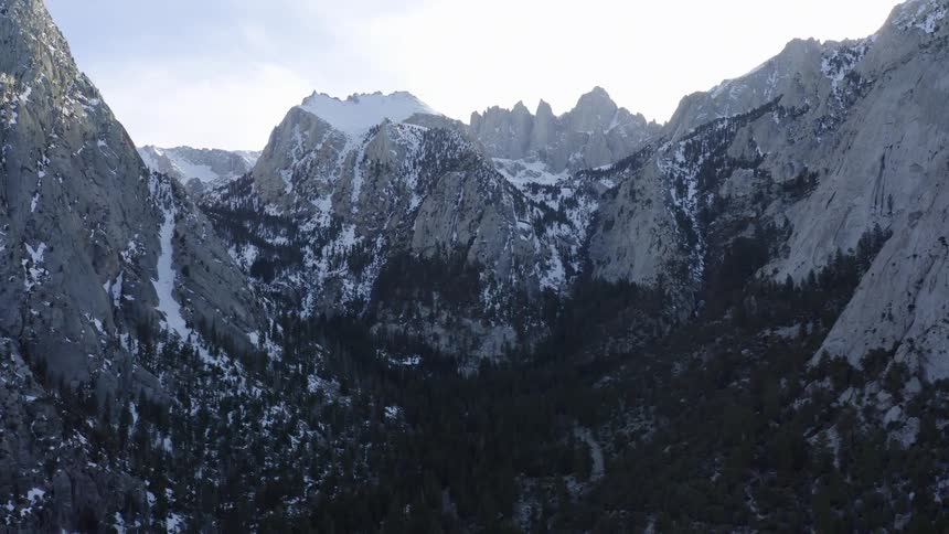 Valley surrounded by snow covered mountain tops at morning