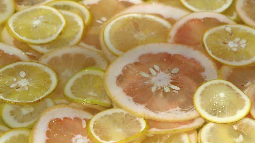 Piled up slices of oranges and limes over a surface