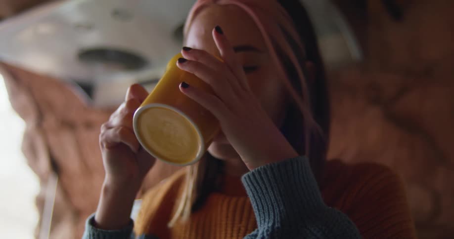 Woman drinking a hot beverage in the kitchen of a home built inside a cave