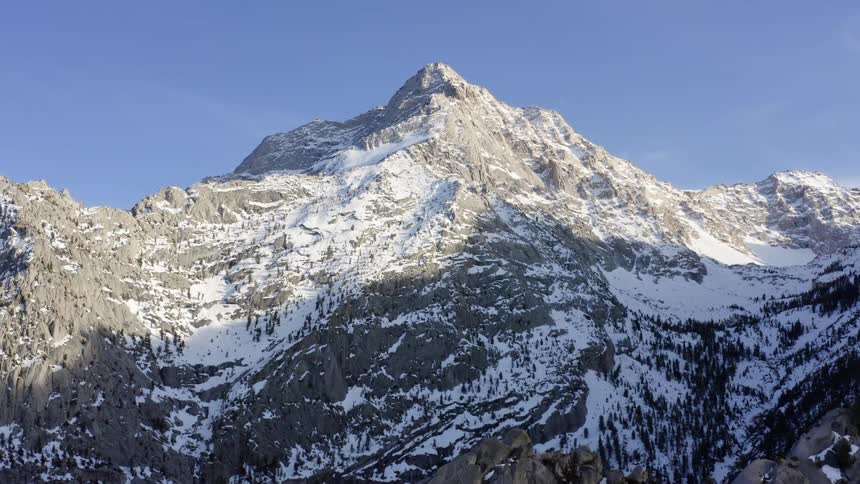 An aerial view of a mountain with snow on it