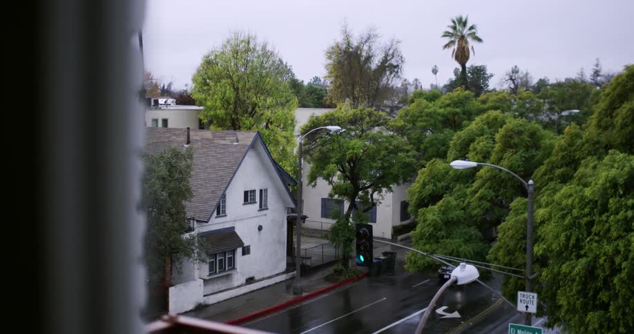 Cars drive on a neighborhood street below