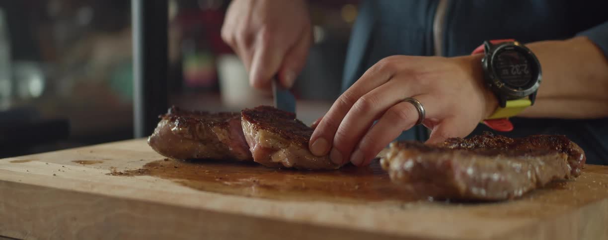 A man cutting a steak on a cutting board