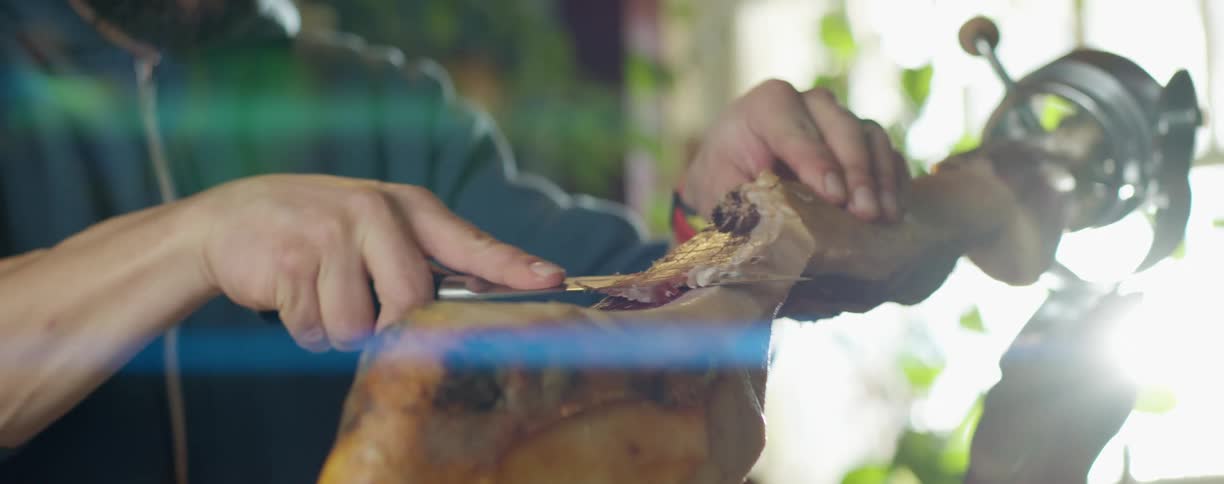 A man cuts meat off a large bone