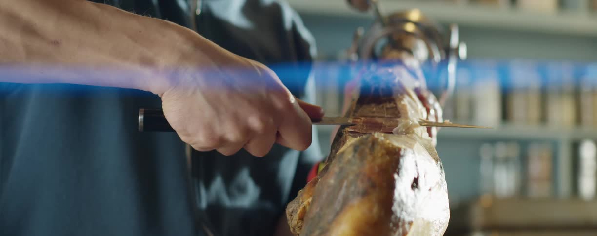 A man cutting meat in a kitchen