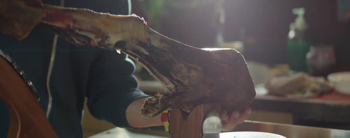 A person putting a bone onto a block in a kitchen