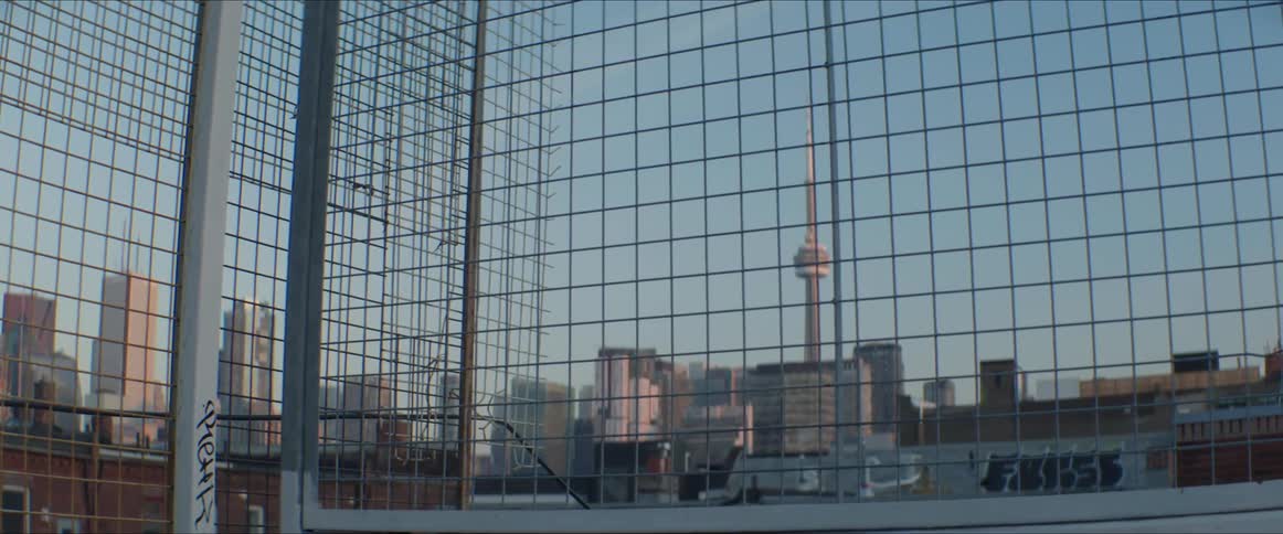 Graffiti is painted on a downtown rooftop with views of the city