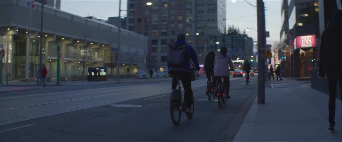 Three cyclist riding bicicles in the city streets at morning