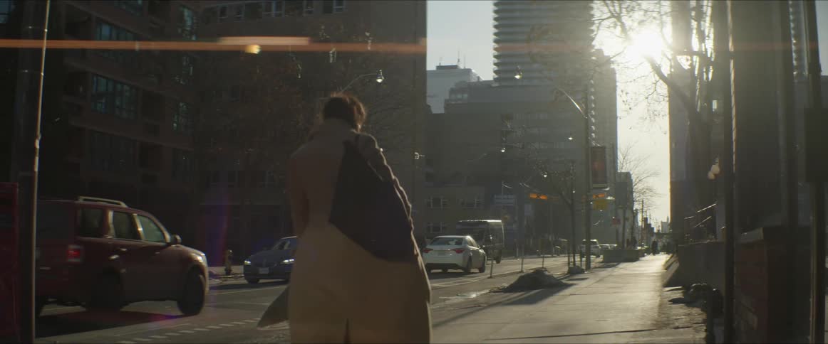 A woman that is walking down a sidewalk in a city