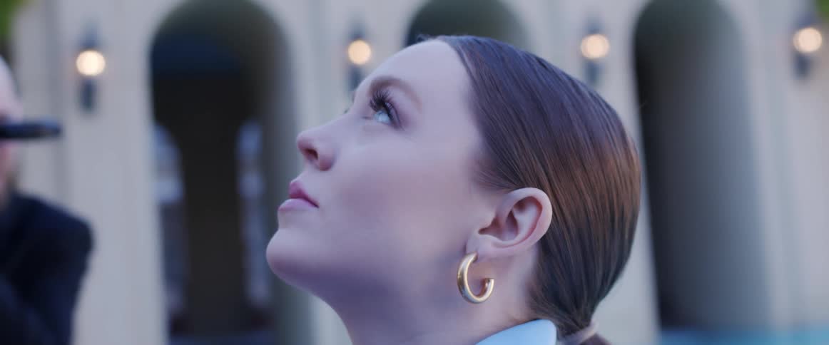 Pale woman looking up in front of a building modeling for the camera