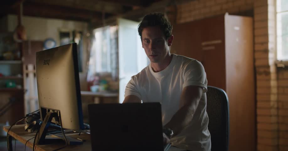 A man typing on computers in a room