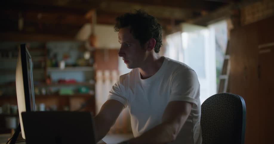 A man sitting at a desk on a computer