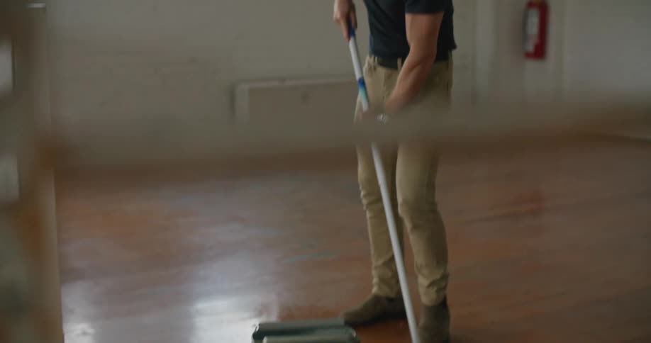 Man mops floor with string mop