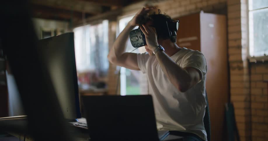 Man sitting at the desk testing virtual reality goggles