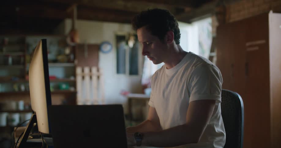 A man using computers and a phone