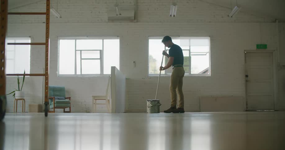 An employee mopping a floor in a building