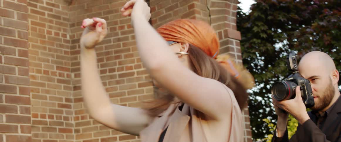 Woman wearing sunglasses and a head band modeling on a photoshoot outside