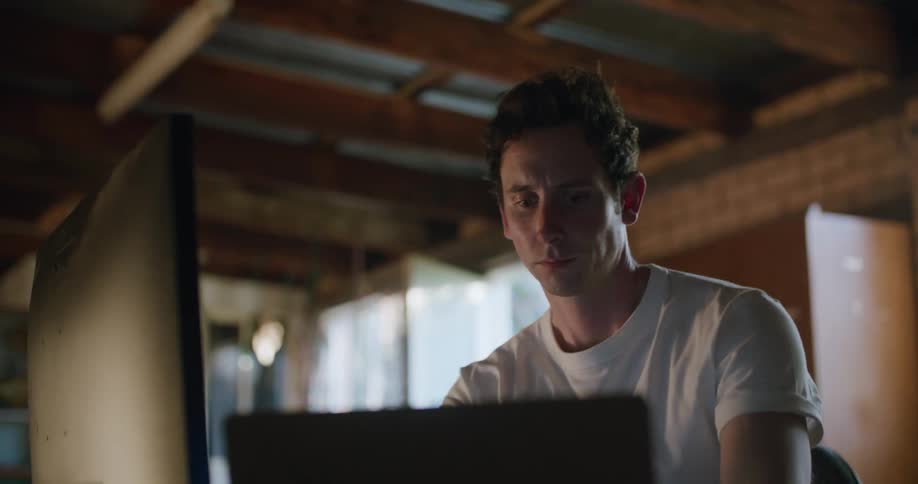 A man stretches his arms behind his head before going to back to work on his computer