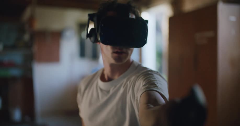 Man sitting inside a garage testing virtual reality goggles