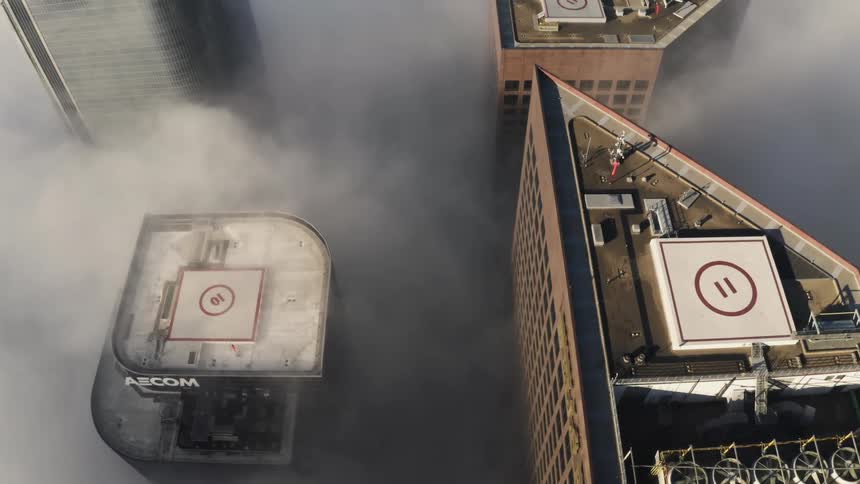 Aerial view of rooftops on high rise buildings from above the clouds