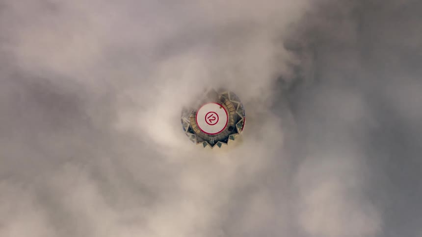 A building with a helicopter pad surrounded by fog