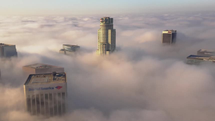An aerial view of a city that is covered in clouds
