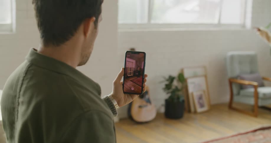 Man and woman use mobile app to place shelves in their living room