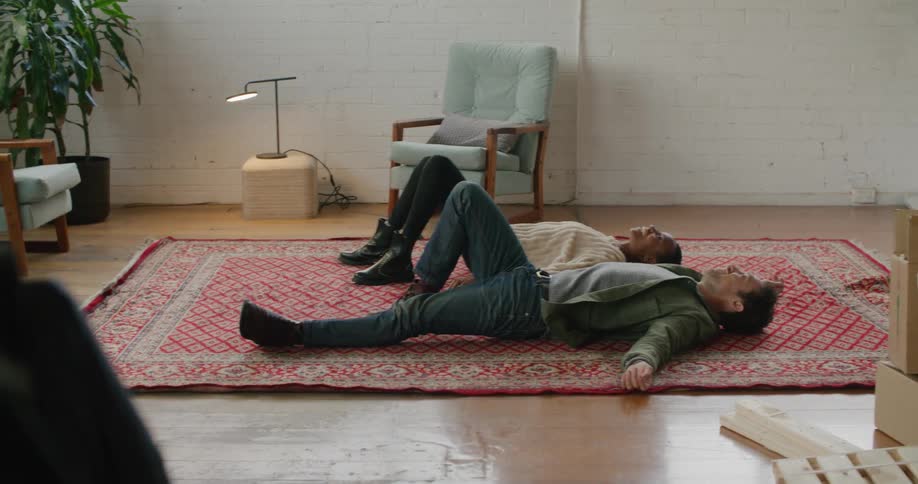 A man and woman laying down on a rug