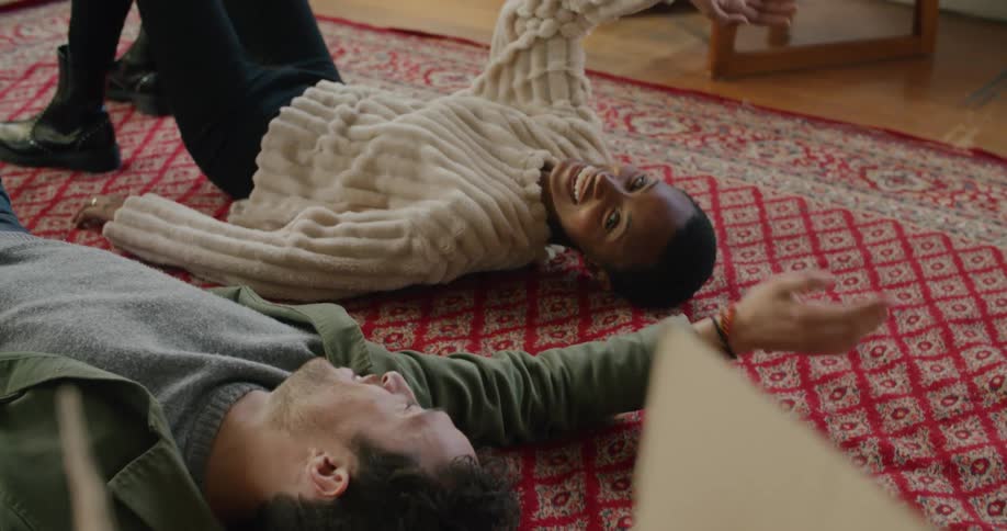A man and woman laying down on the floor of a room