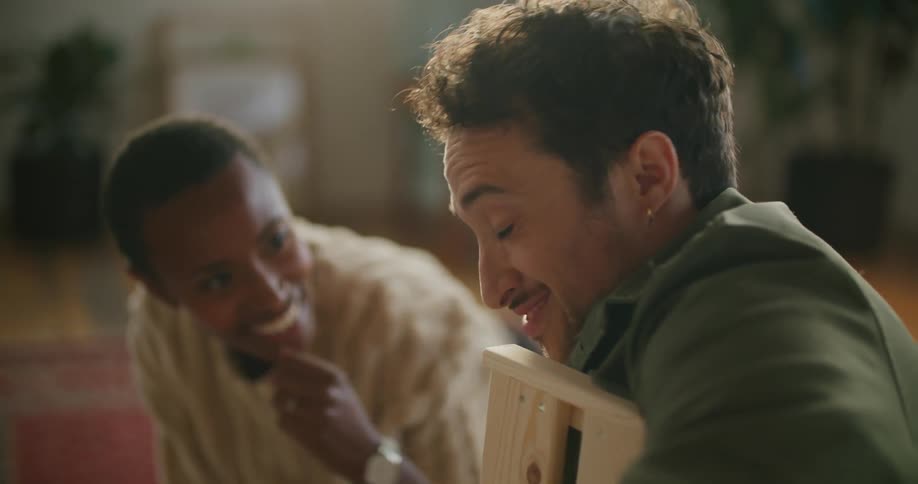 Young couple assembling furniture on the floor in the living room at home