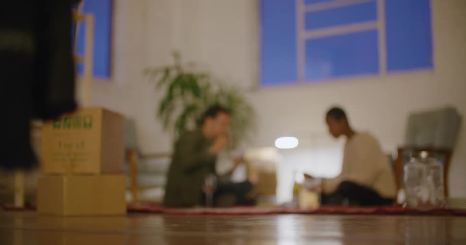 Couple moving to a new home eating dinner in the floor of the living room