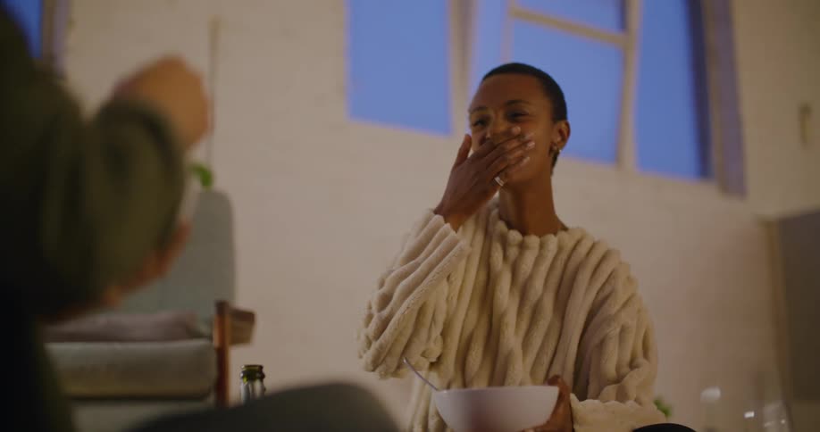 A man and woman eating food and laughing