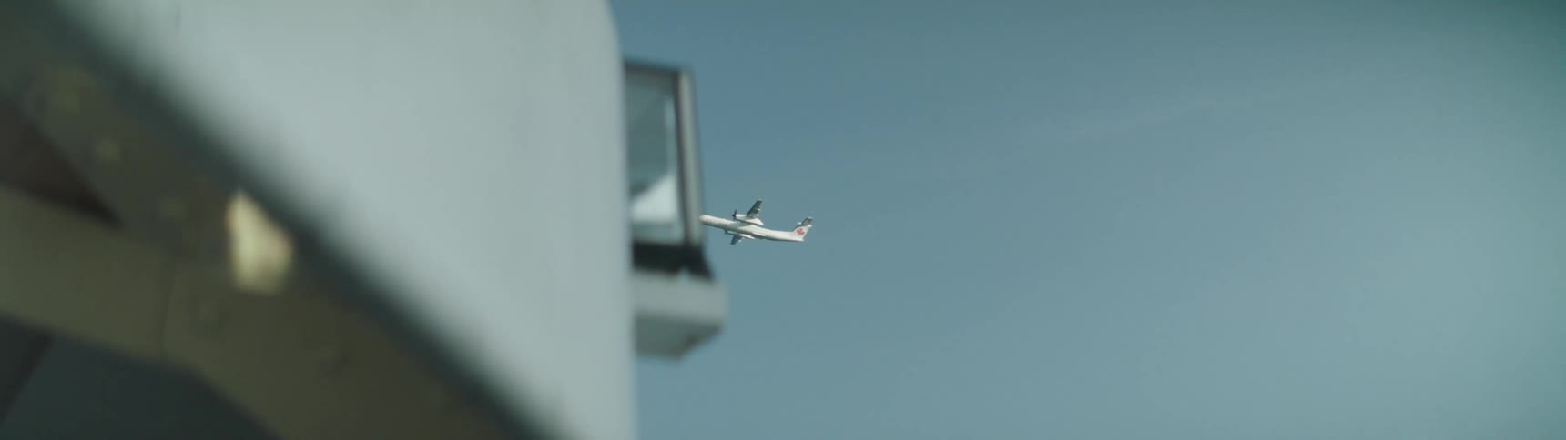 Airliner flies overhead through blue sky
