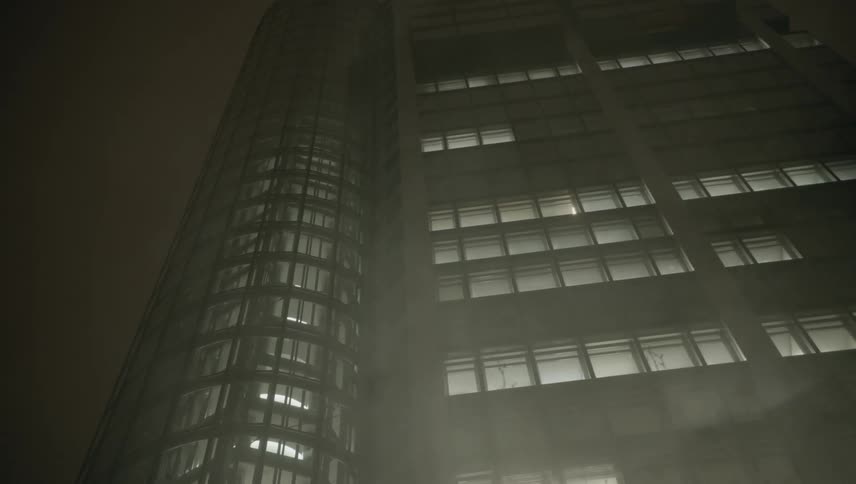 Smokes rises up in front of a tall skyscraper lit up at night