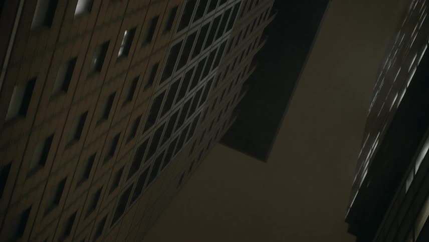 Traveling under street lights posts and signs looking up at city buildings