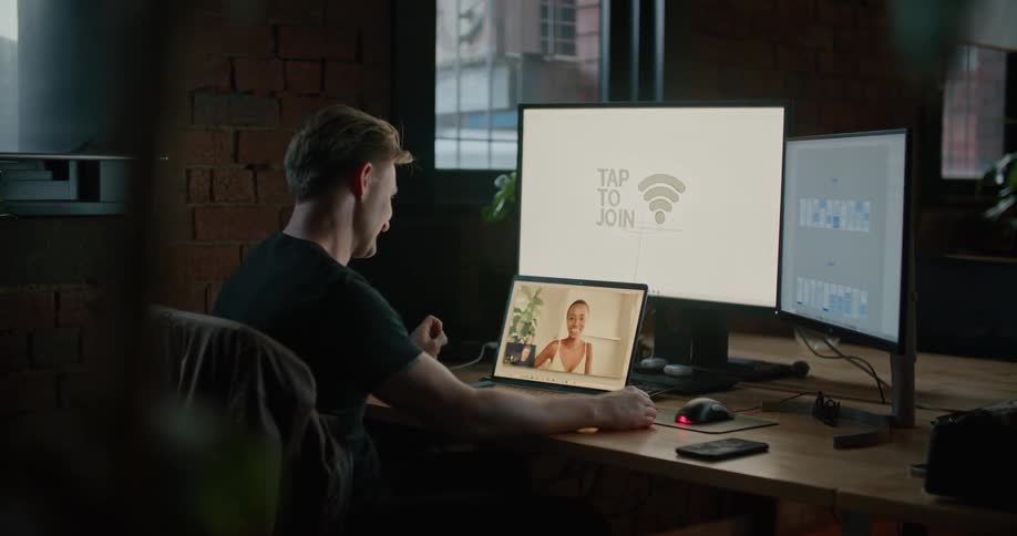 A man that is talking to someone on a laptop