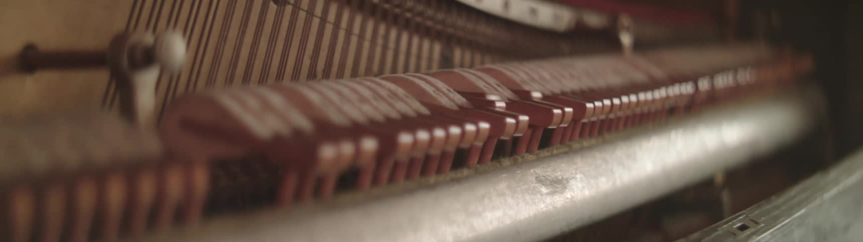 A view of hammers hitting strings in a piano