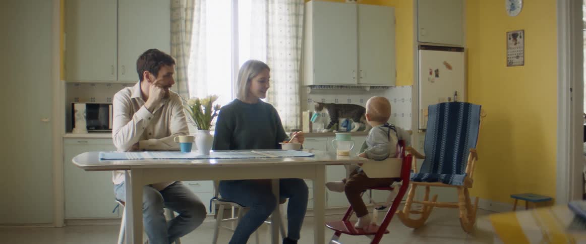A father and mother feeding a baby
