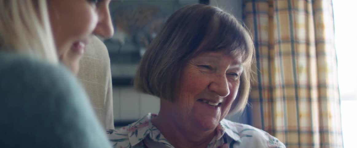 Couple and older woman smile fondly