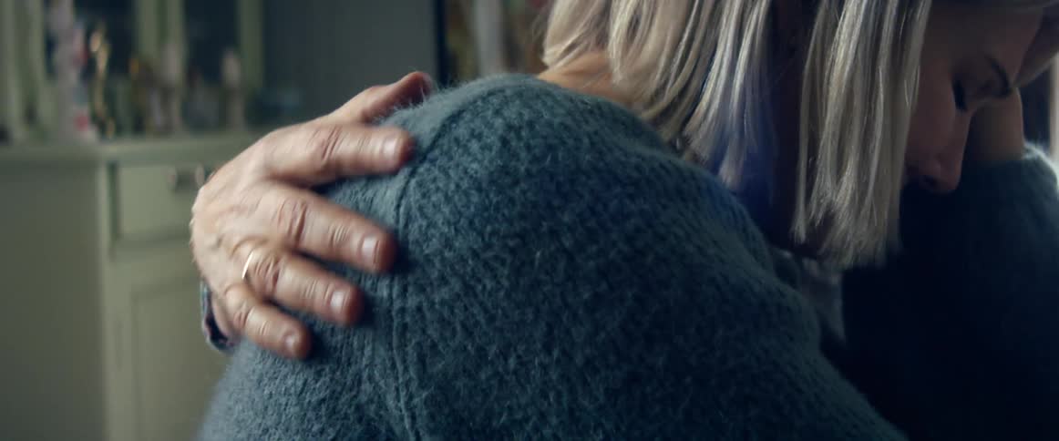 A woman who is distraught and crying is being consoled by an elderly woman