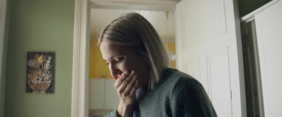A young woman is overjoyed when looking at the results of her pregnancy test and runs to her kitchen