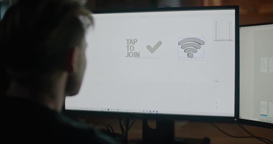 A man moves icons on a computer screen laying out graphics